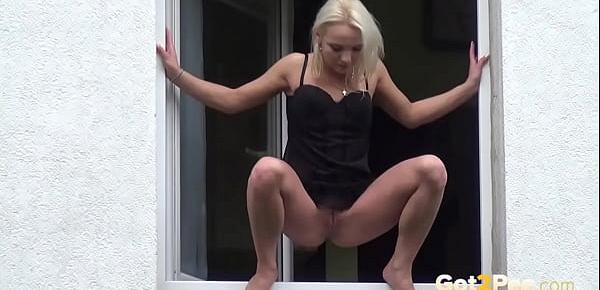  Got2Pee - Blonde babe squats in the window to piss over the edge
